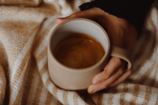 HANDS CRADLING CUP OF COFFEE